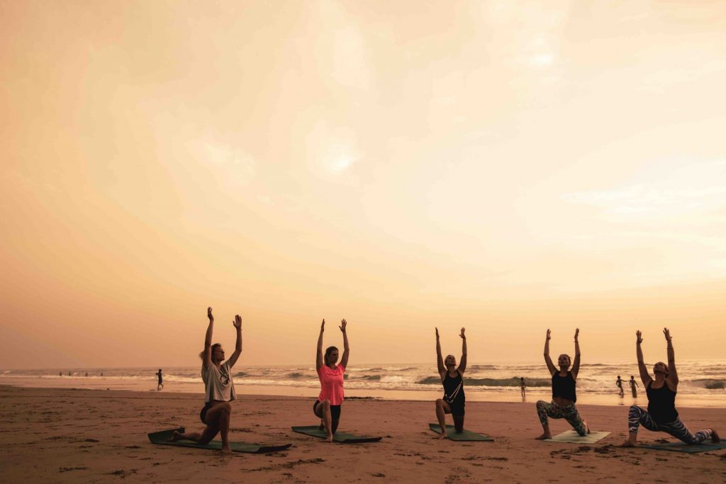 practicing yoga at the beach